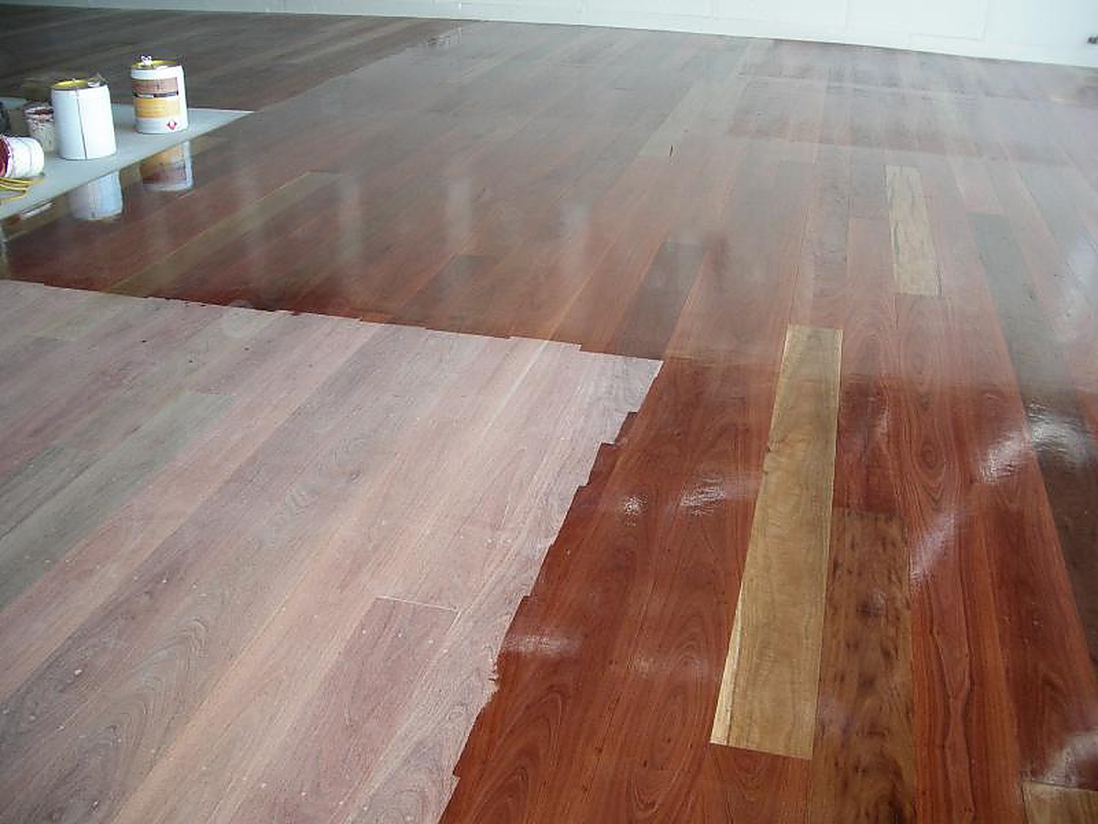 Recycled mixed hardwood boards being coated, with unfinished timber beside a fresh oil-gloss finish
